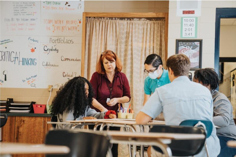 A teacher works with students in a classroom